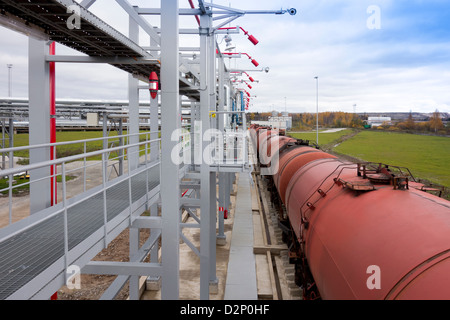 Un olio di scisto impianto di stoccaggio con serbatoi di stoccaggio e vagoni ferroviari per il trasporto del prodotto di estrazione di olio da roccia. Foto Stock