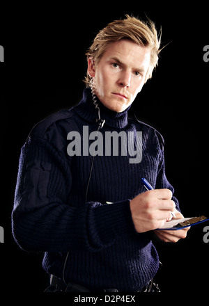 Bello polizia a dovere con una penna a scrivere qualcosa sul suo note Foto Stock