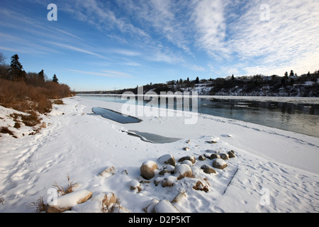 Frozen River Bank del sud del Fiume Saskatchewan in inverno che scorre attraverso il centro cittadino di Saskatoon Saskatchewan Canada Foto Stock