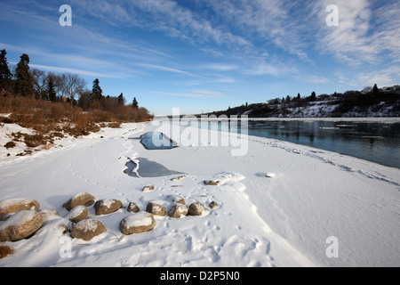 Frozen River Bank del sud del Fiume Saskatchewan in inverno che scorre attraverso il centro cittadino di Saskatoon Saskatchewan Canada Foto Stock