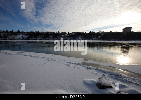 Frozen River Bank del sud del Fiume Saskatchewan in inverno che scorre attraverso il centro cittadino di Saskatoon Saskatchewan Canada Foto Stock