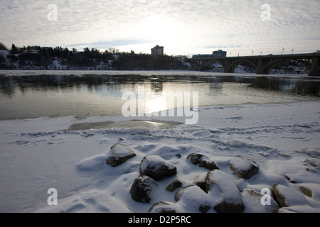 Frozen River Bank del sud del Fiume Saskatchewan in inverno che scorre attraverso il centro cittadino di Saskatoon Saskatchewan Canada Foto Stock