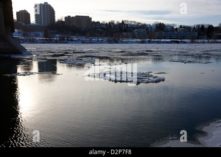 Grandi pezzi di ghiaccio galleggiante a sud del Fiume Saskatchewan in inverno che scorre attraverso il centro cittadino di Saskatoon Saskatchewan Canada Foto Stock