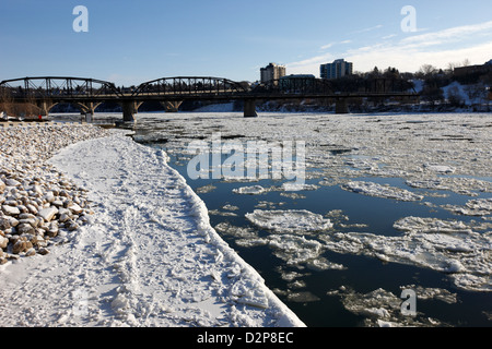 Grandi pezzi di ghiaccio galleggiante a sud del Fiume Saskatchewan in inverno che scorre attraverso il centro cittadino di Saskatoon Saskatchewan Canada Foto Stock