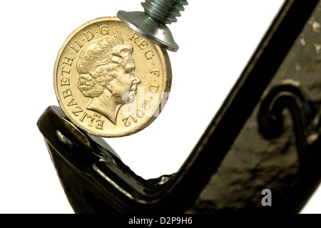 Una sterlina britannica coin in un morsetto - per illustrare il concetto di valuta sterlina sotto pressione, REGNO UNITO Foto Stock