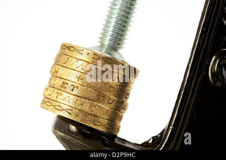 Sterlina britannica monete in un morsetto - per illustrare il concetto di valuta sterlina sotto pressione, REGNO UNITO Foto Stock