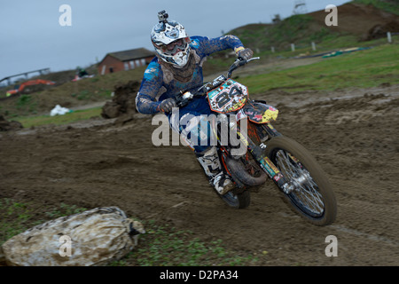Un pilota di motocross a cavallo su una pista di motocross Foto Stock