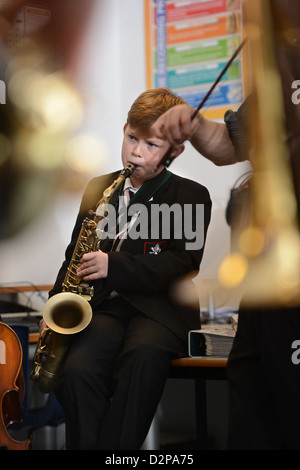 Un ragazzo giocando un sassofono durante una banda pratica presso Pâté Grammar School di Cheltenham, Gloucestershire REGNO UNITO Foto Stock