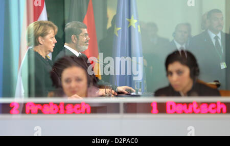 Il cancelliere tedesco Angela Merkel e il Presidente dell'Egitto Mohamed Morsi sono riflesse nel riquadro della finestra del interpretes' box durante una conferenza stampa congiunta presso la cancelleria federale a Berlino, Germania, 30 gennaio 2013. Foto: WOLFGANG KUMM Foto Stock