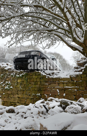 Una Range Rover si è schiantato attraverso una parete dopo lo scorrimento in condizioni di neve su una collina conosciuto localmente sono 'La Scala' nella Nailsworth ne Foto Stock