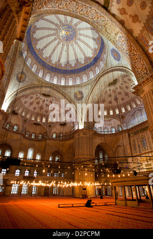 ISTANBUL TURCHIA - Moschea Blu ( Sultan Ahmet Camii ) interno con uomo musulmano prega sulla red tappetino, Sultanahmet Foto Stock