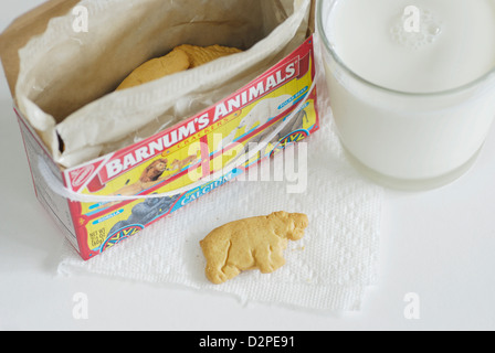 Crackers animale con box e un bicchiere di latte di mucca, ippona posti sulla parte esterna della scatola sul tovagliolo Foto Stock