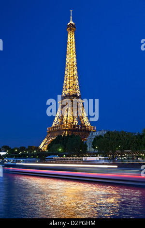 La Torre Eiffel e la barca striatura di luce sul Fiume Senna, Parigi, Francia Foto Stock