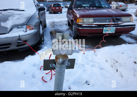 Alimentazione esterna collegata in uscita per i riscaldatori monoblocco di auto nel parcheggio pubblico Saskatoon Saskatchewan Canada Foto Stock