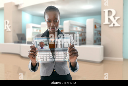 African American imprenditrice mediante il display digitale in farmacia Foto Stock