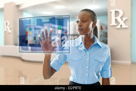 African American imprenditrice mediante il display digitale in farmacia Foto Stock