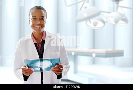 Medico nero azienda digitale compressa in sala operatoria Foto Stock