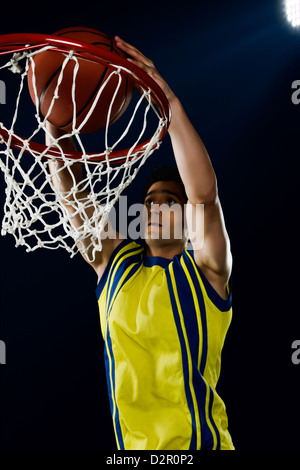 Giocatore di basket dunking una sfera Foto Stock
