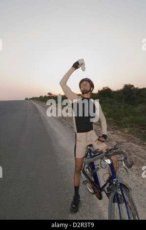 Ciclista versando acqua su se stesso Foto Stock