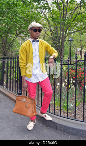 Ritratto di un giovane ed elegante uomo in rosa pantaloni a Washington Square Park nel Greenwich Village di New York City. Foto Stock