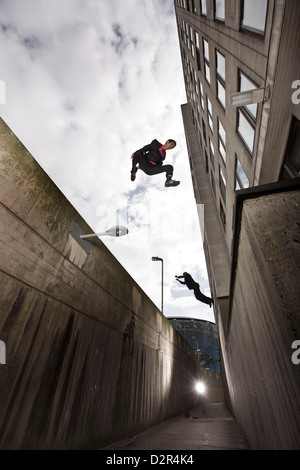 Parkour runner in giacca jumping vicolo urbano Foto Stock