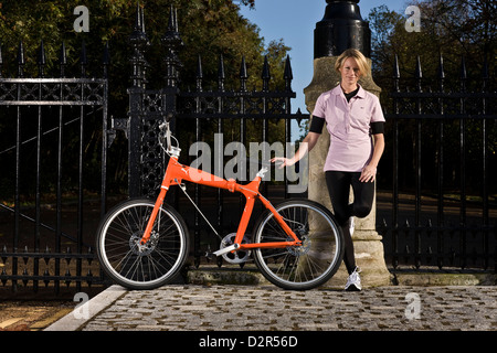 Ciclista femmina si erge con la bici al park di ringhiere, Londra Foto Stock