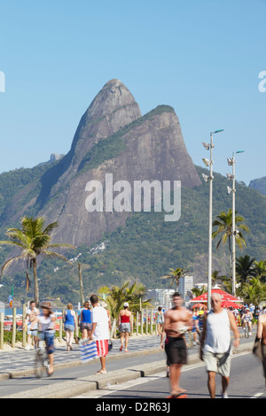 Persone in bicicletta e a piedi lungo la strada pedonale di domenica, Ipanema, Rio de Janeiro, Brasile, Sud America Foto Stock