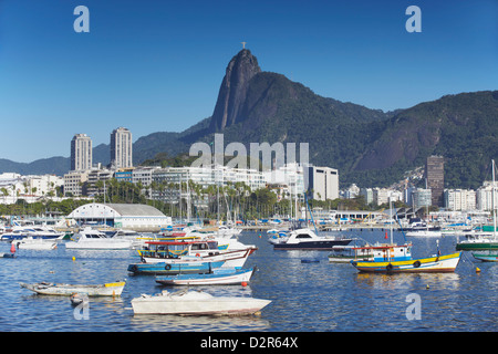 Barche ormeggiate in porto con Cristo il Redentore statua in background, Urca, Rio de Janeiro, Brasile, Sud America Foto Stock