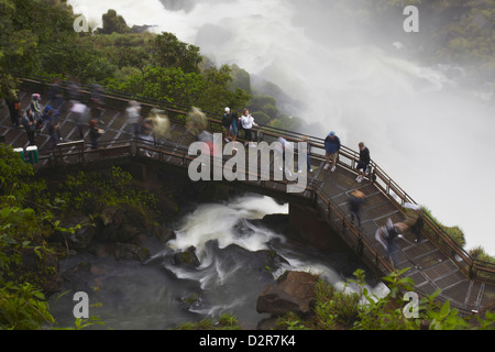 Turisti attraversando ponte a piedi di Bossetti cade, Iguazu Falls, Parco Nazionale di Iguazu, Misiones, Argentina Foto Stock