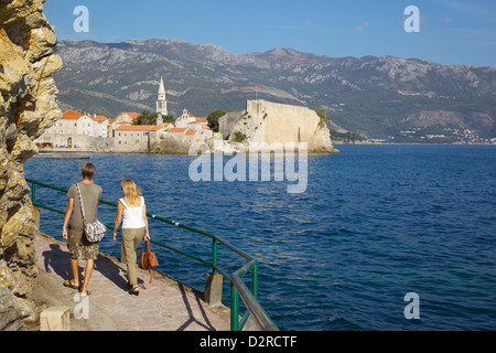 Giovane camminando lungo la costa verso la Città Vecchia, Budva, Montenegro, Europa Foto Stock