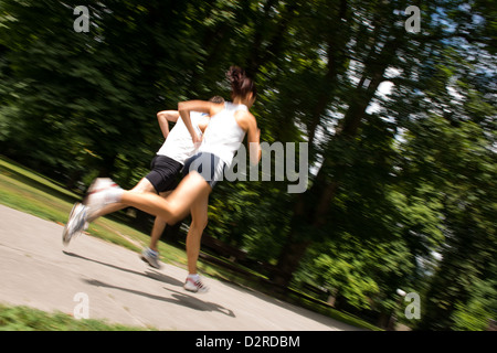 Giovane uomo e donna jogging all'aperto in natura - motion blur immagine (panoramica) Foto Stock