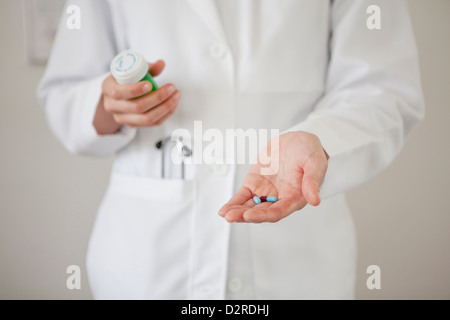 Medico tenendo manciata di pillole Foto Stock