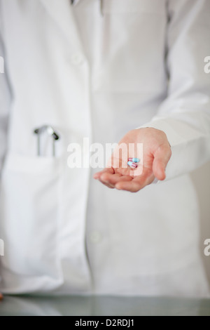 Medico tenendo manciata di pillole Foto Stock