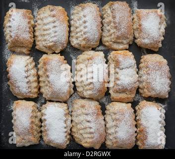 I biscotti con lo zucchero in polvere su sfondo nero Foto Stock