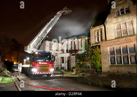 Vigili del Fuoco piattaforma idraulica tetto notte di fuoco Foto Stock