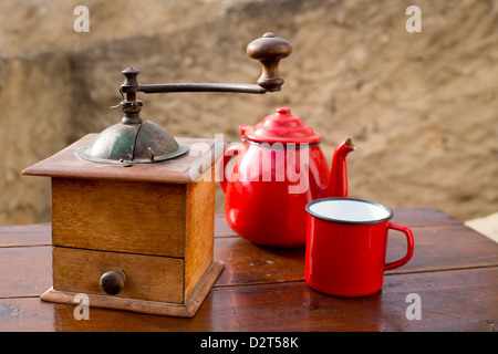 Retrò vecchio macinino da caffè con teiera vintage e bicchiere di rosso Foto Stock