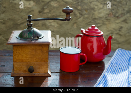 Retrò vecchio macinino da caffè con teiera vintage e bicchiere di rosso Foto Stock