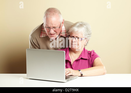 Senior l uomo e la donna utilizzando portatile mentre cercando confuso Foto Stock