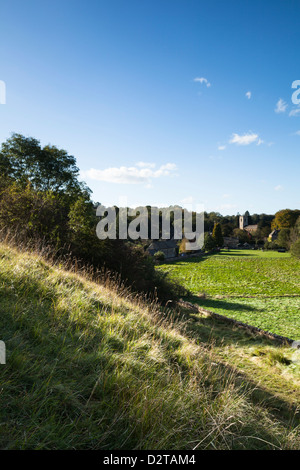 Le case di pietra e di Sant'Andrea chiesa nel villaggio Costwold di Naunton annidata all'interno della valle Windrush, Cotswolds, Inghilterra Foto Stock