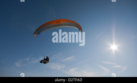 Un airborne parapendio vola in una giornata di sole Foto Stock