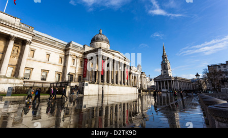 Londra circa 2013: Trafalgar Square acqua di riflessione la mattina dopo la tempesta, soleggiato e nuvoloso mattina a Londra Foto Stock