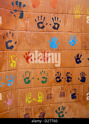 Colorato childrens' handprints su una parete arancione di Austin in Texas Foto Stock