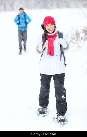 Escursioni con le racchette da neve escursioni invernali. Coppia attiva su racchette da neve all'aperto nella neve a piedi nel parco naturale in Quebec, Canada Foto Stock