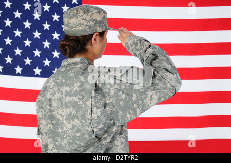 Primo piano di una donna americana soldato in combat uniform salutando un flag. Foto Stock