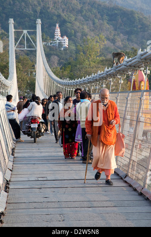 India, Rishikesh. I pedoni sulla sospensione passerella sul Gange (Ganga). Foto Stock