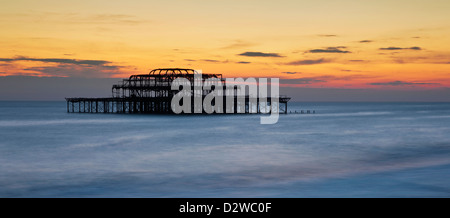 Brighton il bruciato molo Ovest al tramonto in East Sussex, Regno Unito. Foto Stock