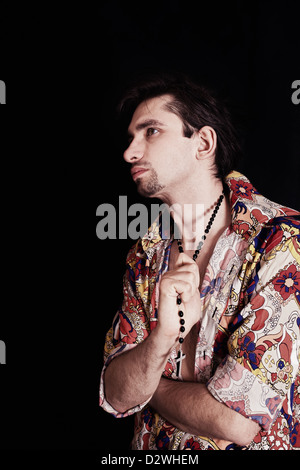 Ritratto di giovane ed elegante uomo su uno sfondo nero Foto Stock