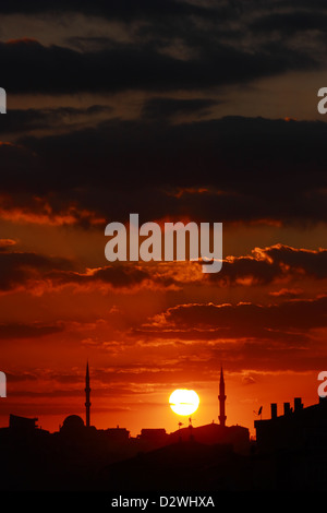 Rosso tramonto in scena con la moschea e minareti - verticale Foto Stock