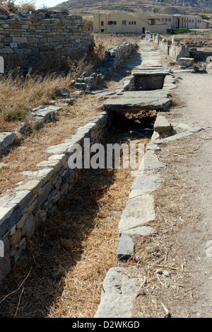Delos . La Grecia. Antica rifiuti fognari canale che passa sotto la strada vicino al lago sacro. Foto Stock