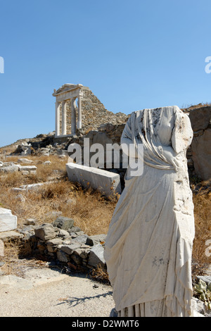 Delos. La Grecia. Decapitati figura femminile scultura in marmo e il restaurato il tempio di Iside presso il Santuario della Divinità egiziane. Foto Stock